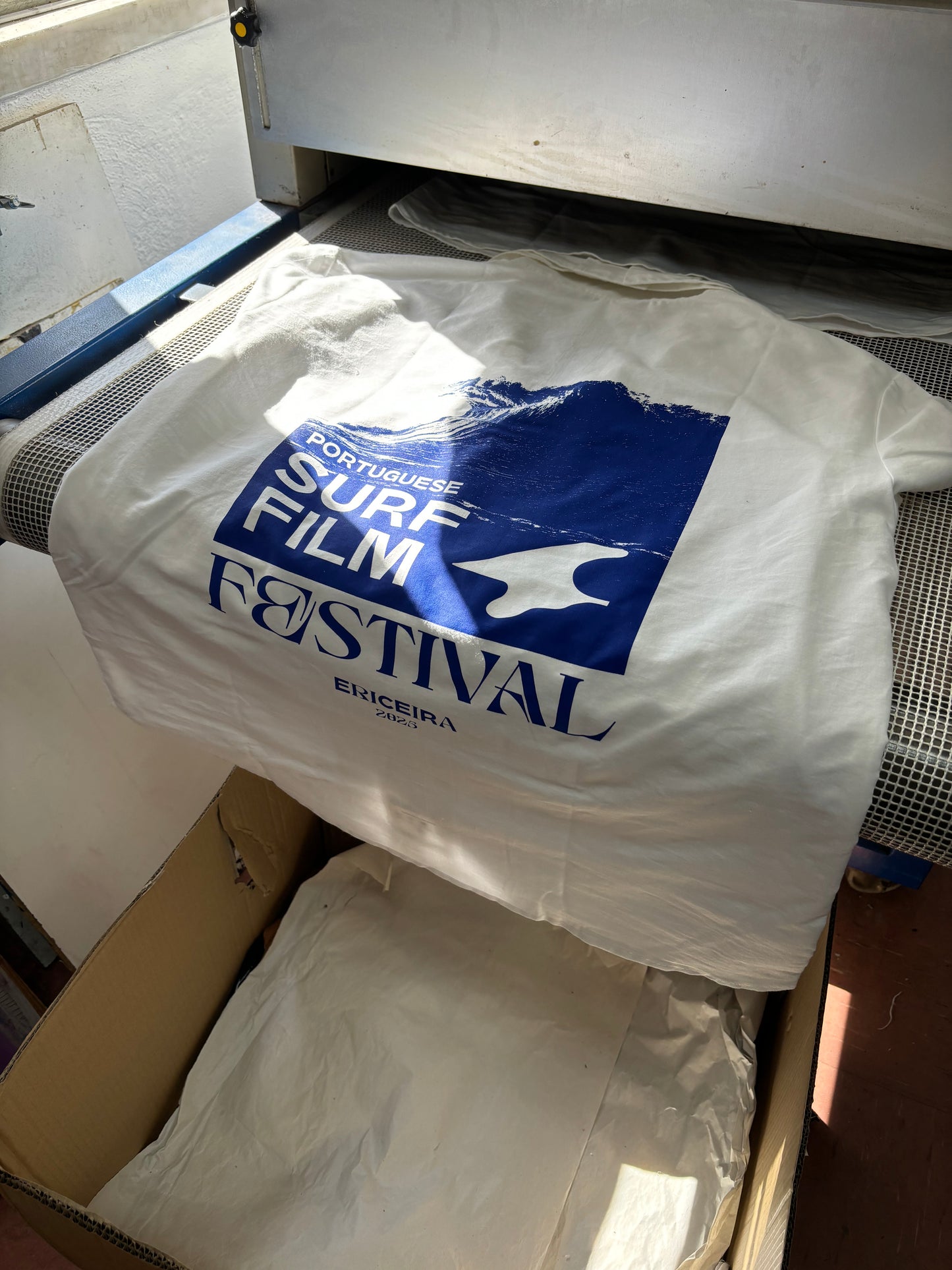 White shirt with blue text and logo on a white surface
